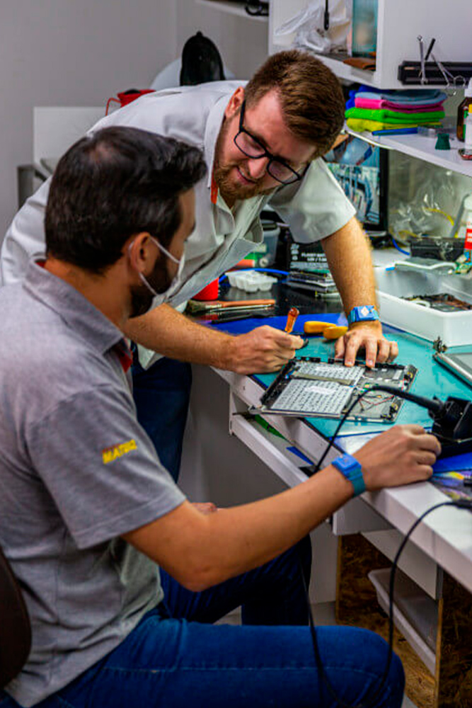 Equipe técnica da Notebooks Goiânia em bancada de reparo com ferramentas de precisão