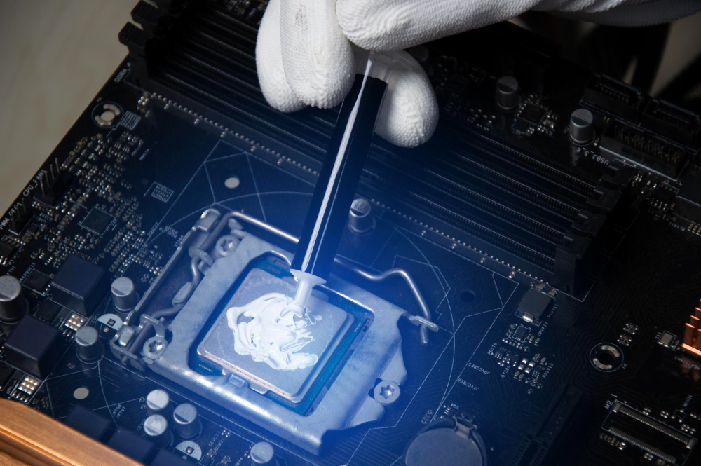 Aplicação de pasta térmica em processador de notebook durante higienização em Goiânia