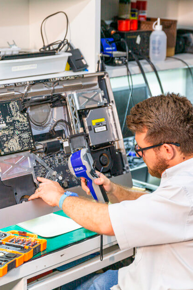 Técnico especialista realizando microsolda em placa lógica de notebook em Goiânia